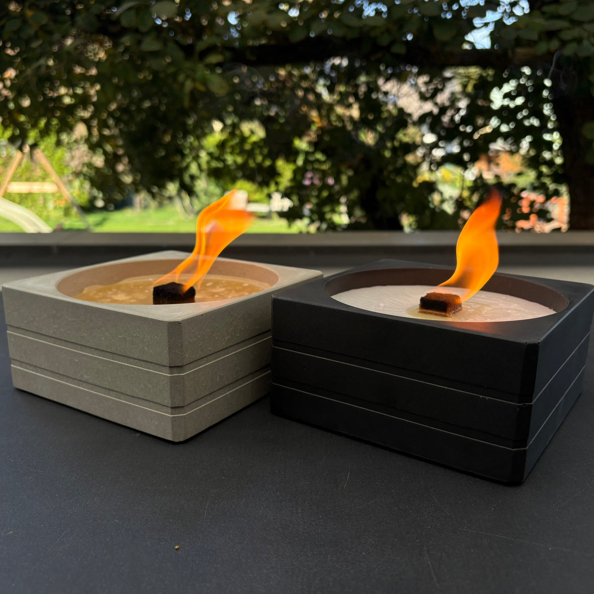 Dauerfeuer SQUARE in Grau und Anthrazit nebeneinander, beide brennend
